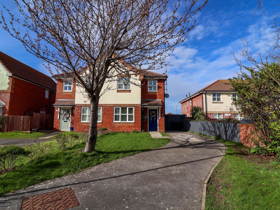 A house with a tree and a sidewalk at The Beach Escape Prestatyn