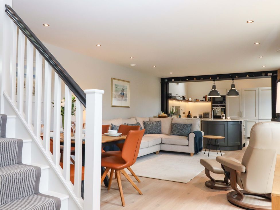 A living room with a staircase and kitchen island at Duke's Barn Blackawton near Dartmouth