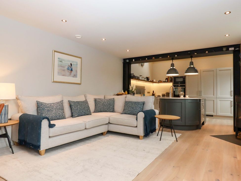 A living room with a sofa and kitchen island at Duke's Barn in Blackawton near Dartmouth