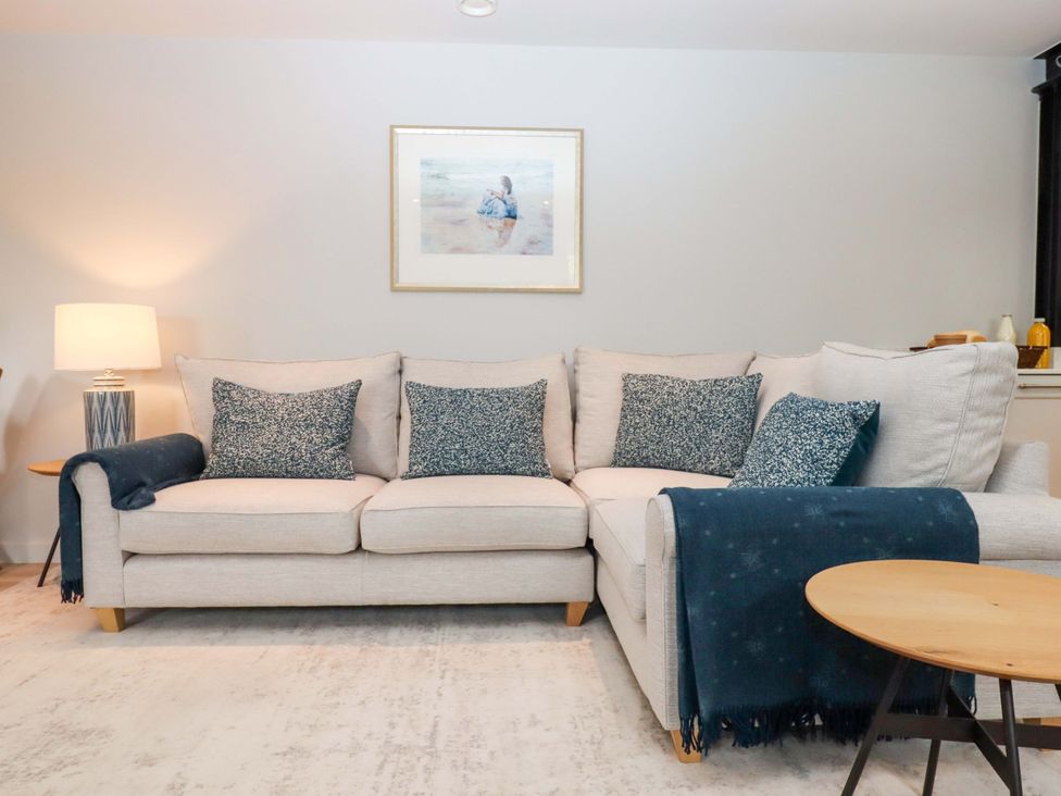 A living room with a sofa and decorative cushions at Duke's Barn in Blackawton near Dartmouth