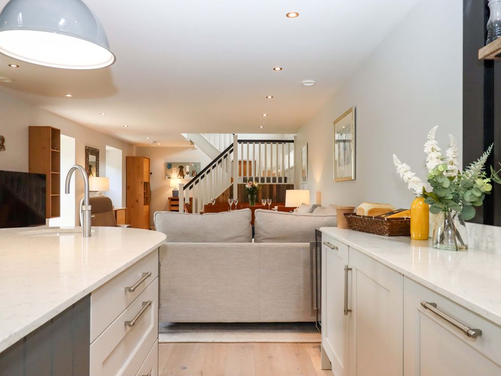A living room with a sofa and kitchen island at Duke's Barn Blackawton near Dartmouth