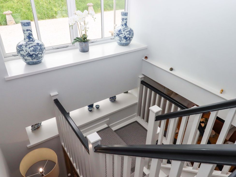 A staircase with vases and a flower pot at Duke's Barn Blackawton near Dartmouth