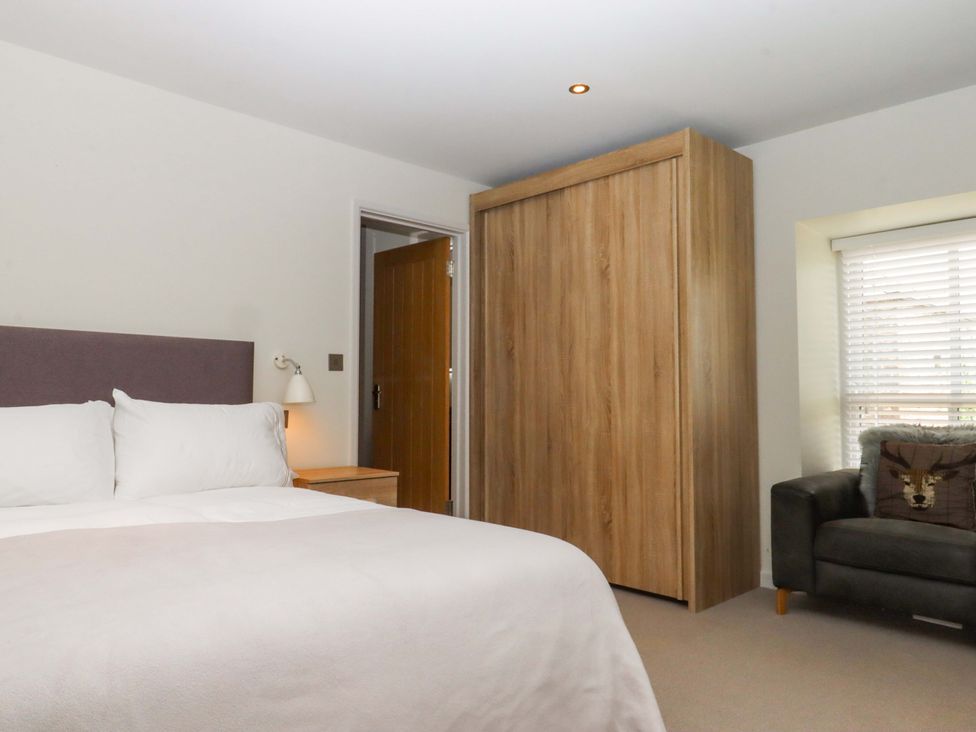 A bedroom with a bed and a wardrobe at Duke's Barn in Blackawton near Dartmouth