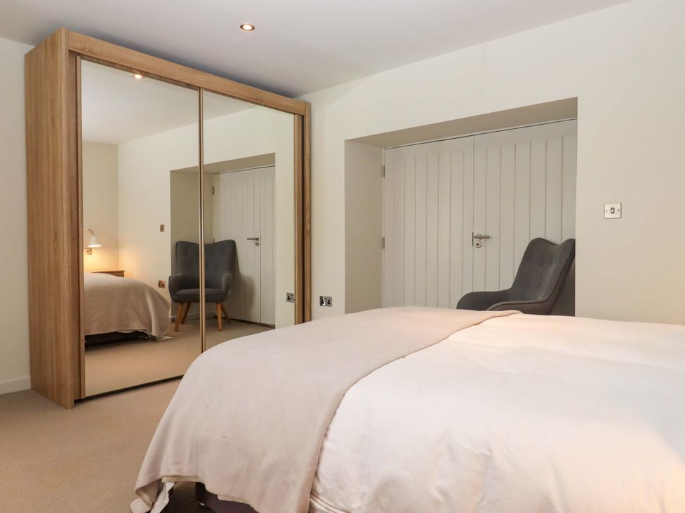 A bedroom with a bed and a chair at Duke's Barn in Blackawton near Dartmouth