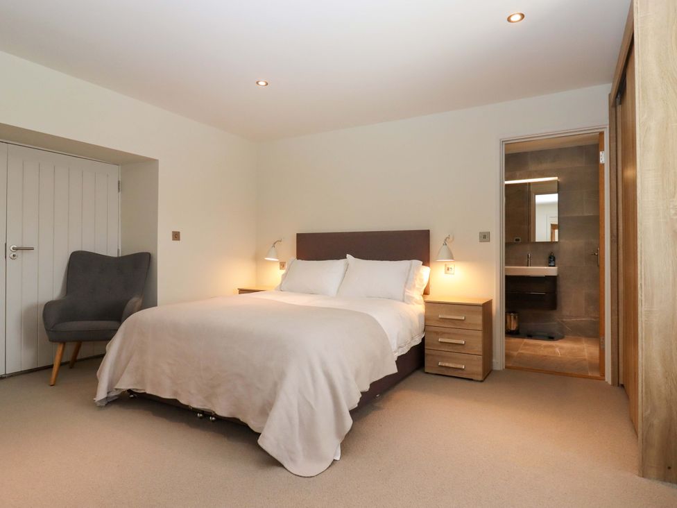 A bedroom with a bed and a chair at Duke's Barn Blackawton near Dartmouth