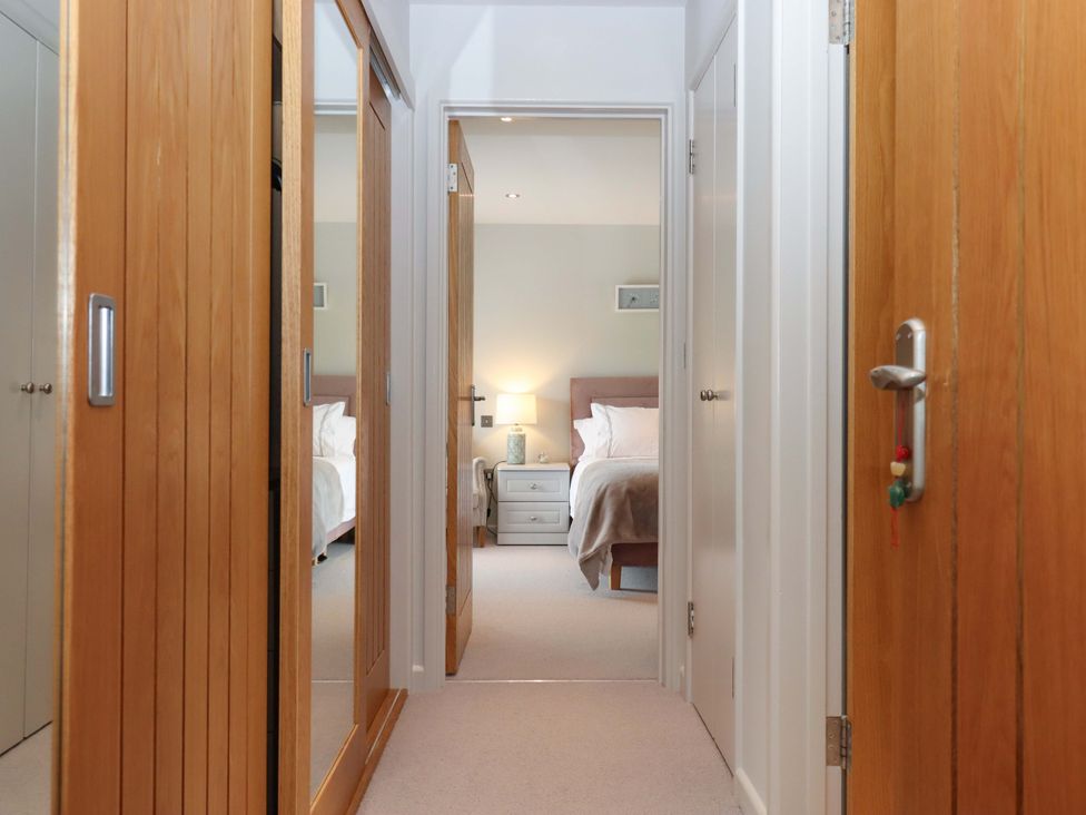 A hallway view into a bedroom with a lamp and nightstand at Duke's Barn Blackawton near Dartmouth