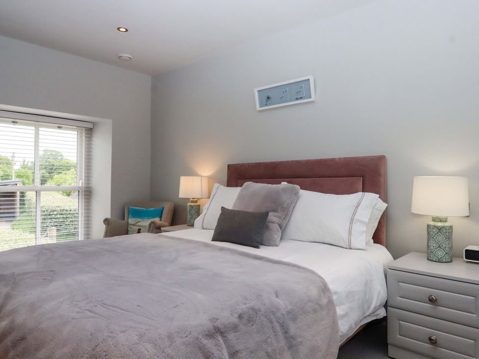 A bedroom with a bed and nightstand at Duke's Barn near Blackawton