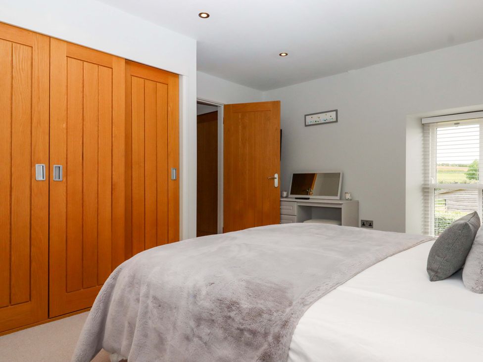 A bedroom with a bed and wardrobe at Duke's Barn Blackawton near Dartmouth