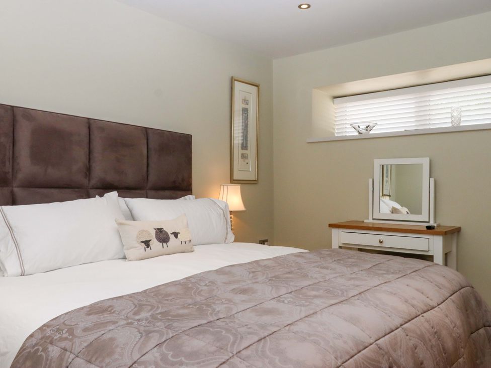 A bedroom with a bed and a mirror at Duke's Barn near Dartmouth