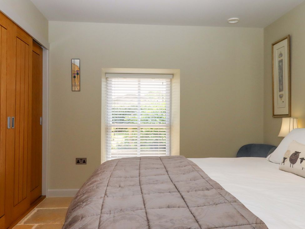 A bedroom with a bed and wardrobe at Duke's Barn Blackawton near Dartmouth