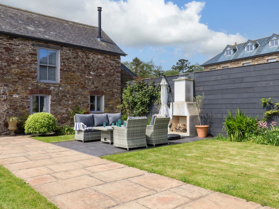 A garden with seating area and fireplace at Duke's Barn Blackawton near Dartmouth