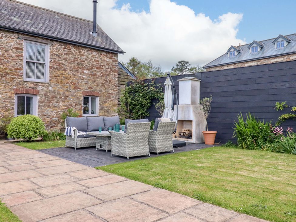 A garden with seating area and fireplace at Duke's Barn Blackawton near Dartmouth