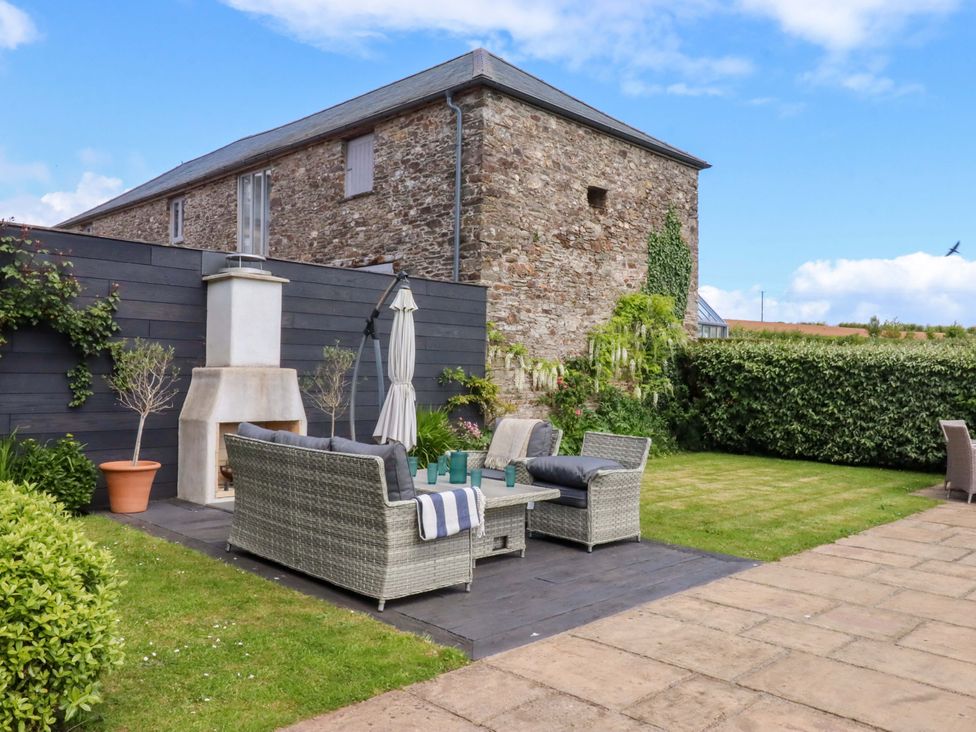 A garden with a seating area and fireplace at Duke's Barn in Blackawton near Dartmouth