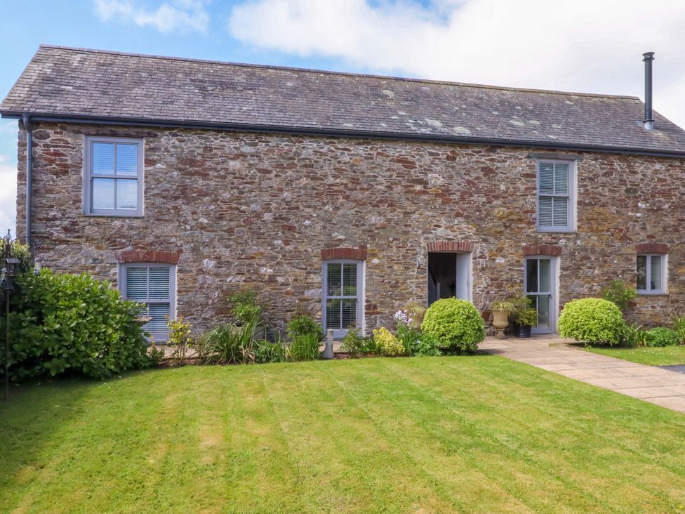An outdoor view of a stone building with a garden at Duke's Barn Blackawton near Dartmouth