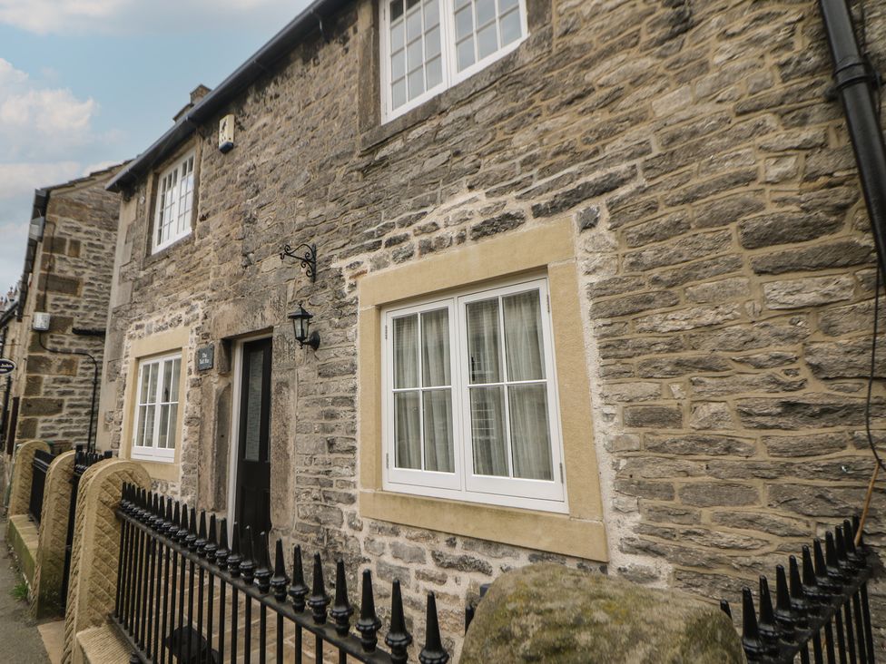A stone cottage exterior with windows and a door at The Toll Bar in Hope Valley