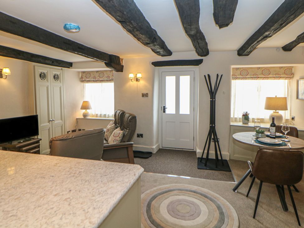 A living room with sofa, coffee table, and dining area at The Toll Bar in Hope Valley