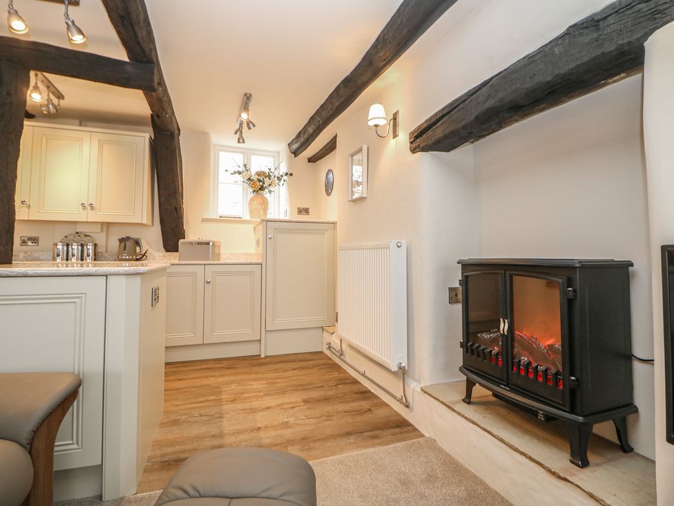A kitchen with cabinets and an electric fireplace at The Toll Bar in Hope Valley