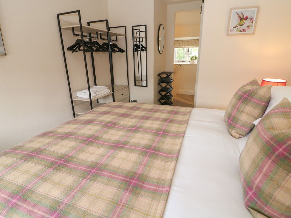 A bedroom with a bed and storage racks at The Toll Bar in Hope Valley