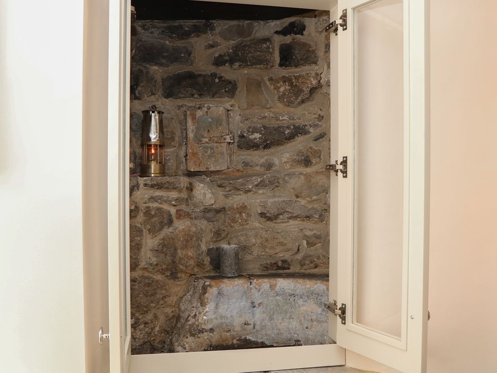 A storage area with a stone wall and a lantern at The Toll Bar in Hope Valley