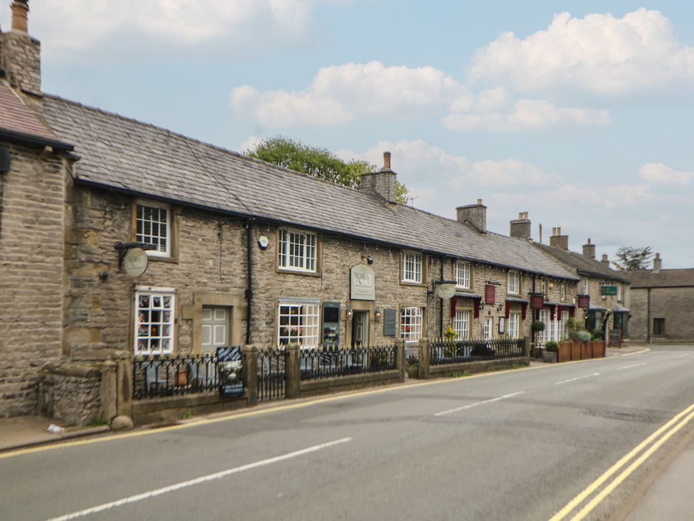 A street with stone buildings and a road at The Toll Bar in Hope Valley