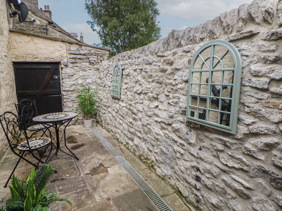 An outdoor seating area with a table and chairs at The Toll Bar in Castleton, Peak District
