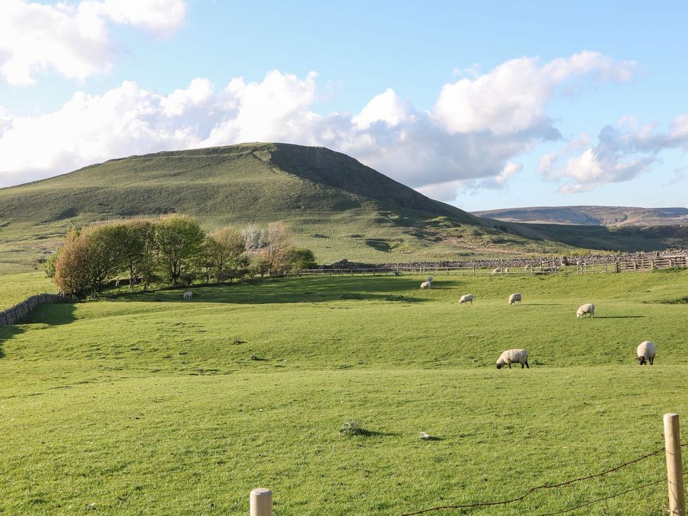 A scenic landscape with sheep grazing in a field at The Toll Bar in Castleton, Peak District