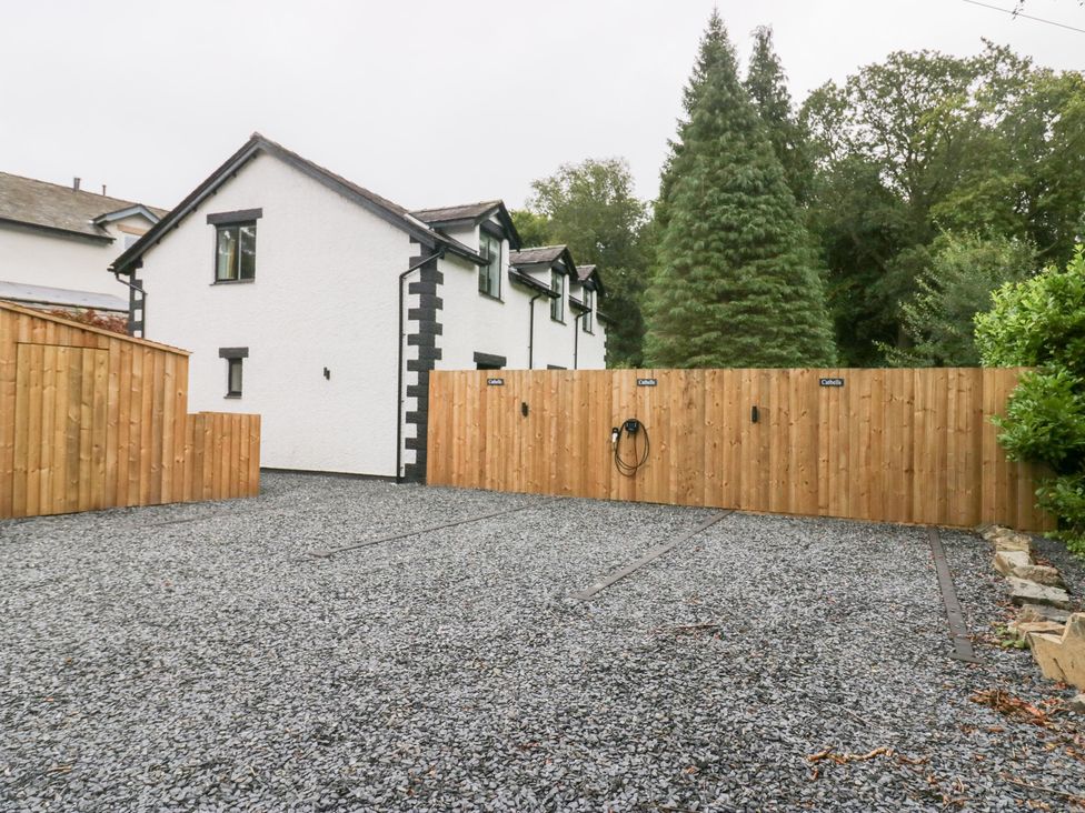 An outdoor area with gravel parking and trees at Catbells in Windermere