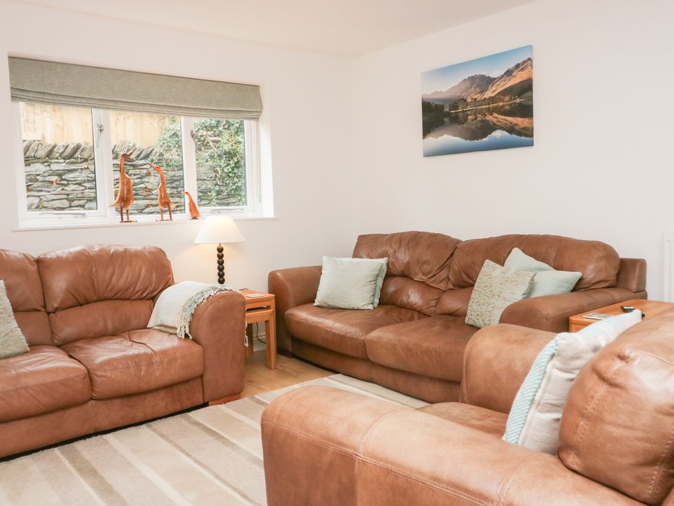 A living room with brown sofas and a lamp at Catbells in Windermere