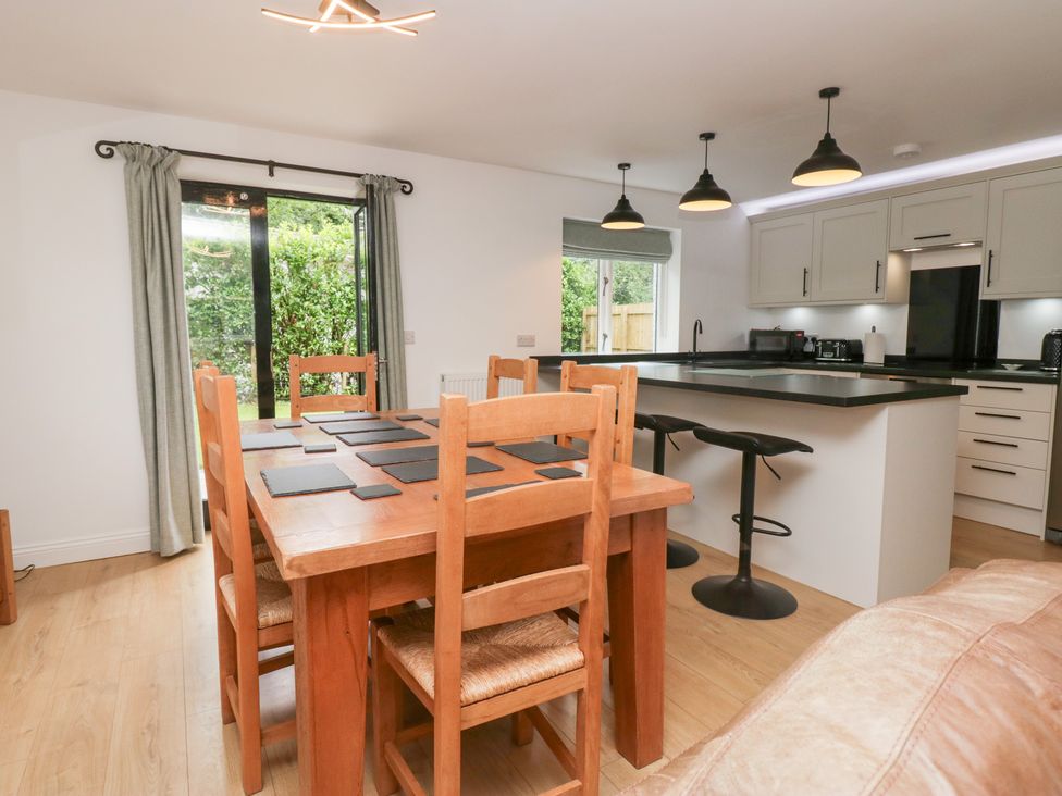 A dining area with wooden table and bar stools at Catbells in Windermere