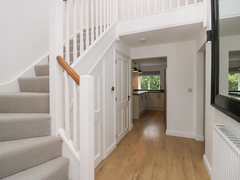 A hallway with a staircase leading to an upper floor at Catbells in Windermere
