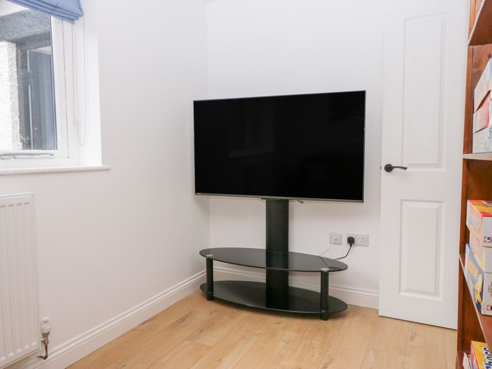 A living room with a television mounted on a stand at Catbells in Windermere
