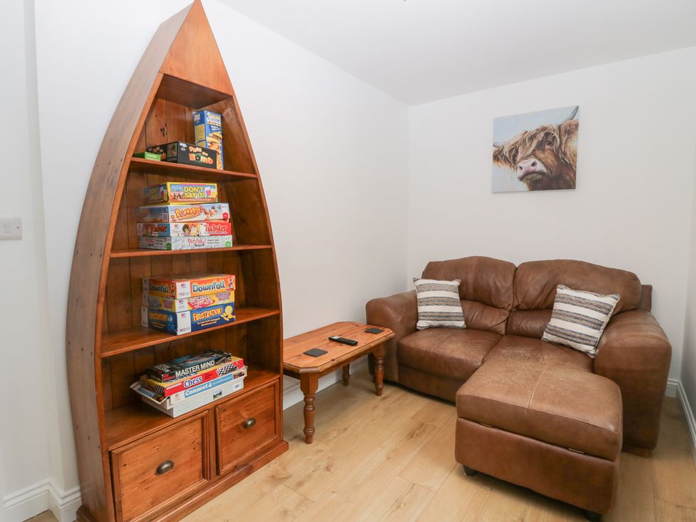 A living room with a bookshelf and a sofa at Catbells in Windermere