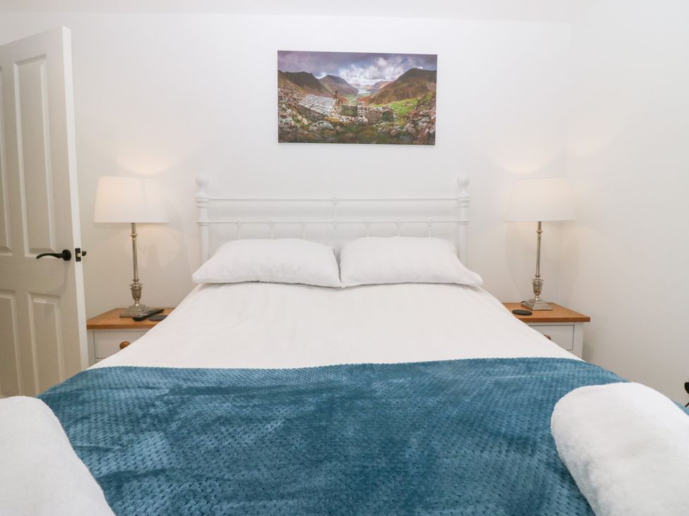 A bedroom with a bed, nightstand, and lamp at Catbells in Windermere