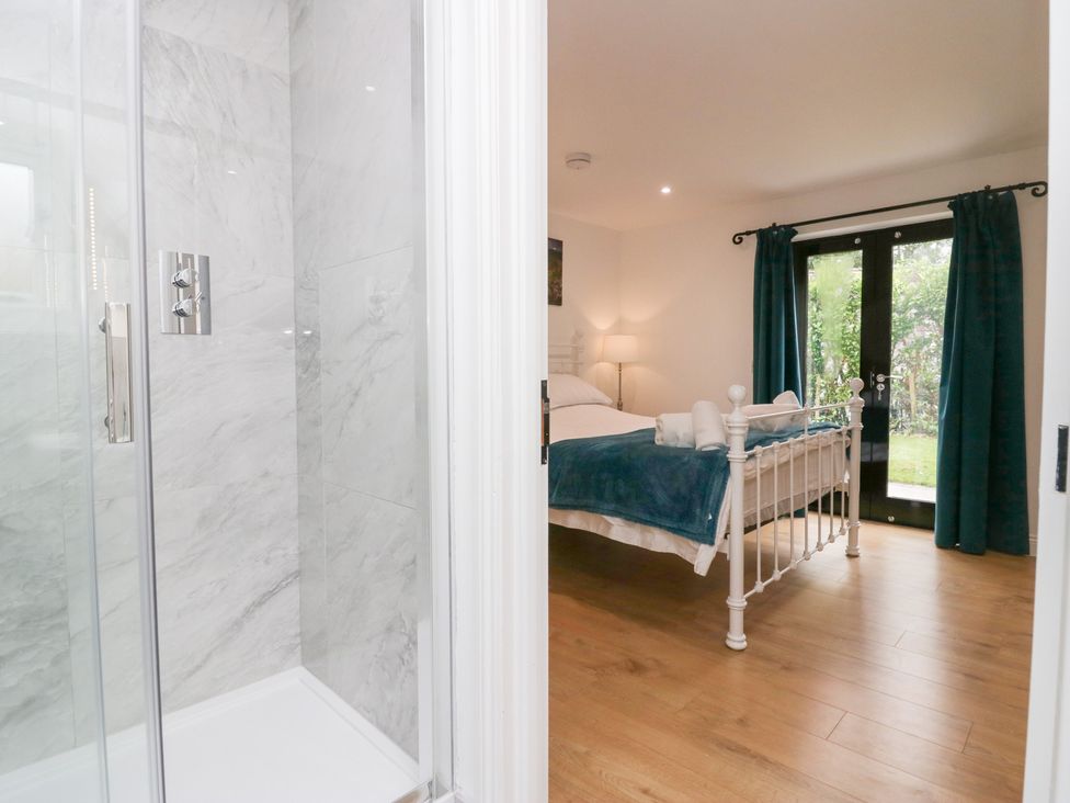 A bedroom with a bed and a shower visible at Catbells in Windermere