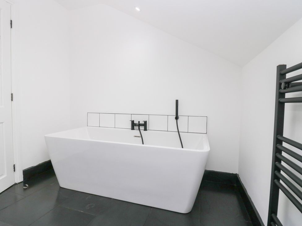 A bathroom with a bathtub and towel warmer at Catbells in Windermere
