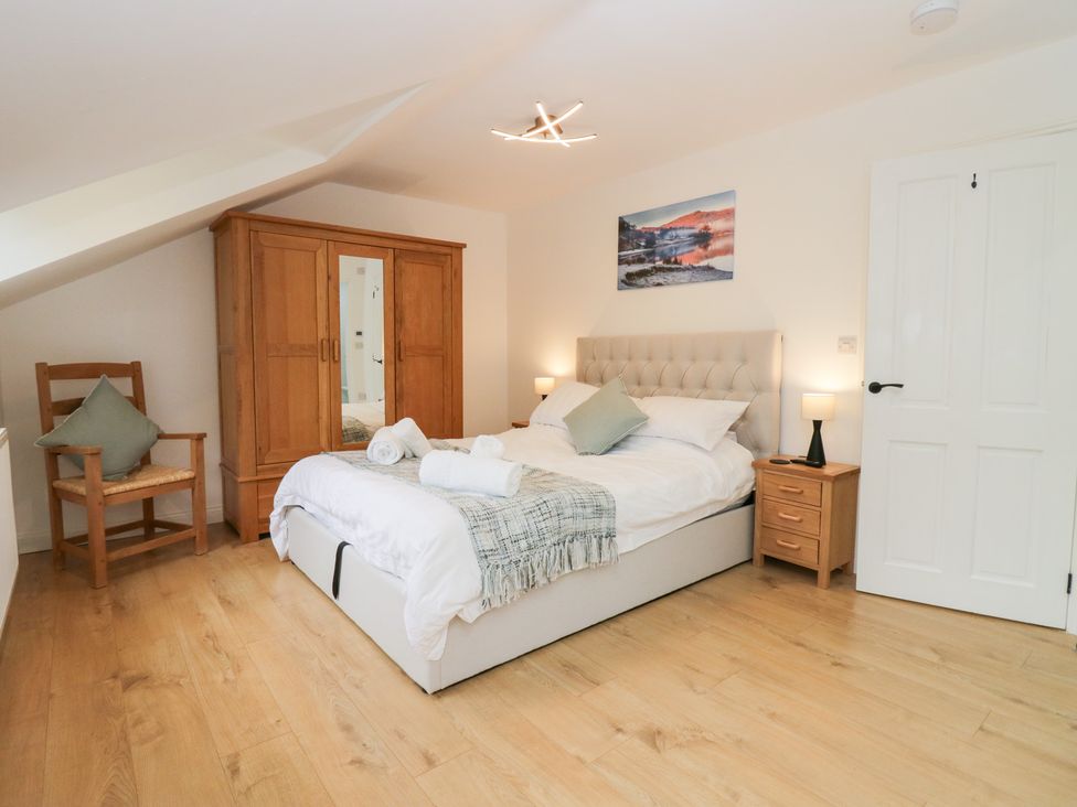 A bedroom with a bed and wardrobe at Catbells in Windermere