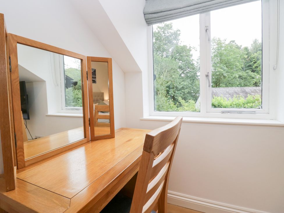 A dressing table and window with trees outside at Catbells in Windermere