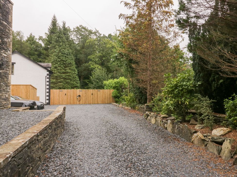 An outdoor space with a gravel driveway and trees at Catbells in Windermere