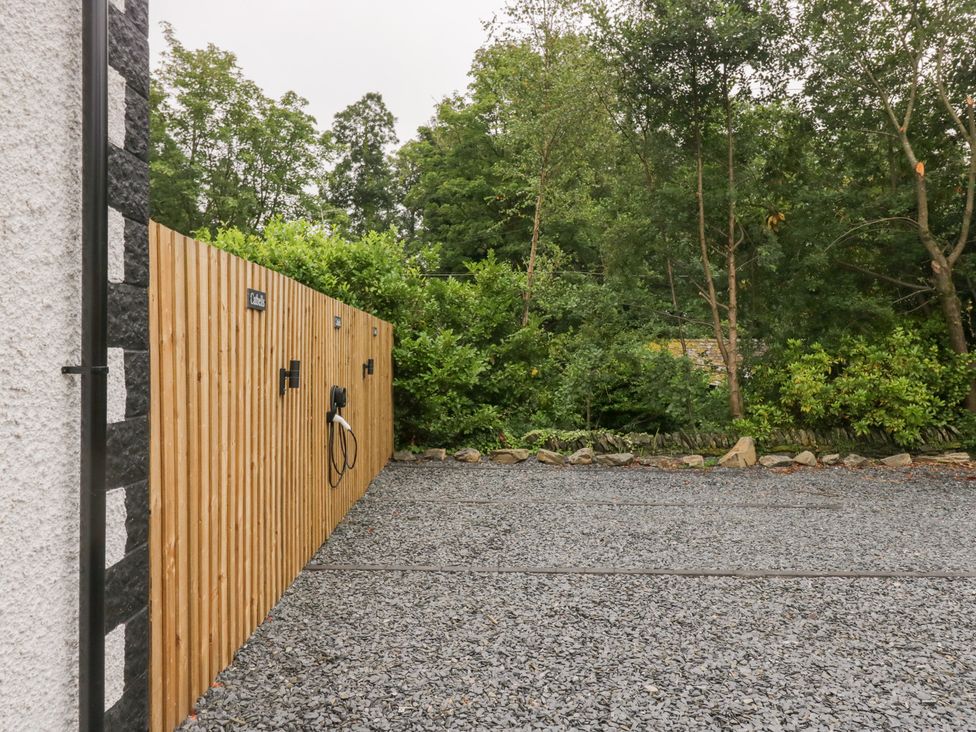 An outdoor area with a wooden fence and gravel surface at Catbells in Windermere