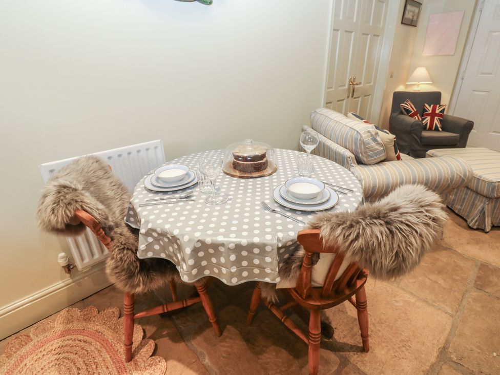 A dining area with a table set for two and a sofa at The Annex