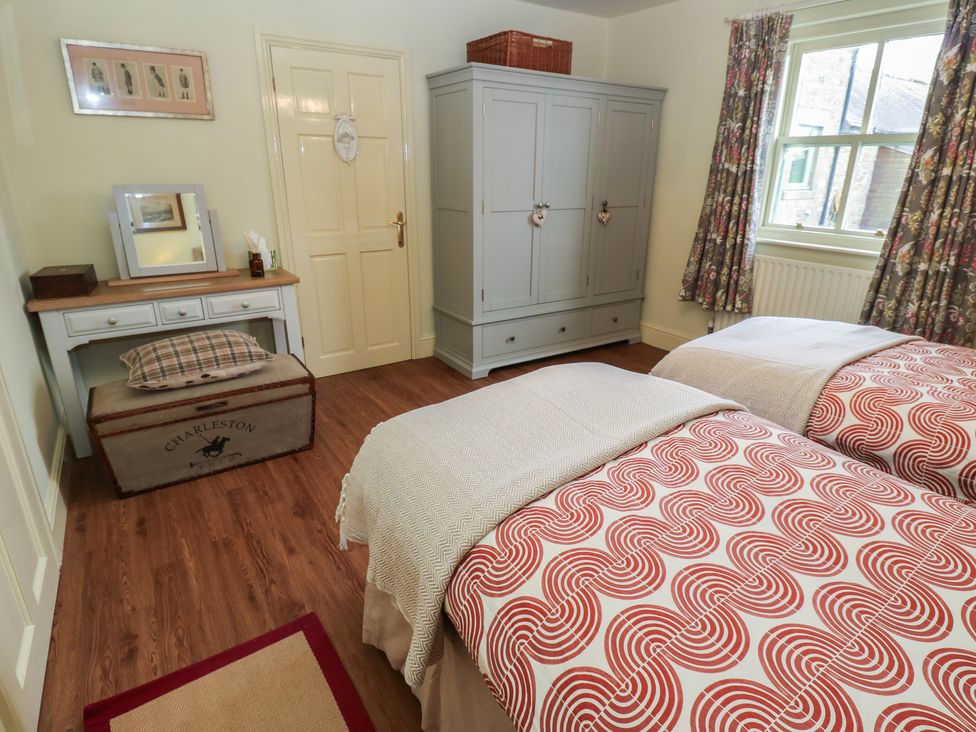 A bedroom with two beds and a wardrobe at The Annex in 