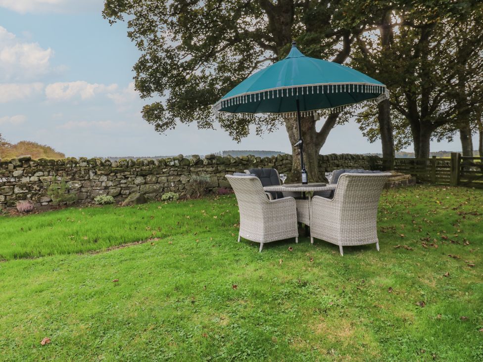 A table and chairs under an umbrella in a garden at The Annex 