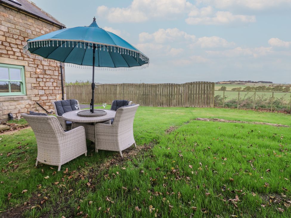 A garden with a table and chairs under an umbrella at The Annex 