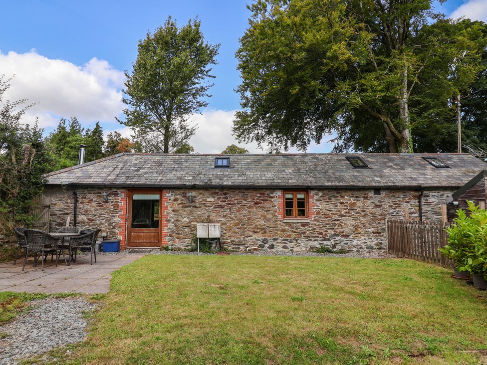 An outdoor view of a stone cottage with a patio at The Coach House in Tavistock