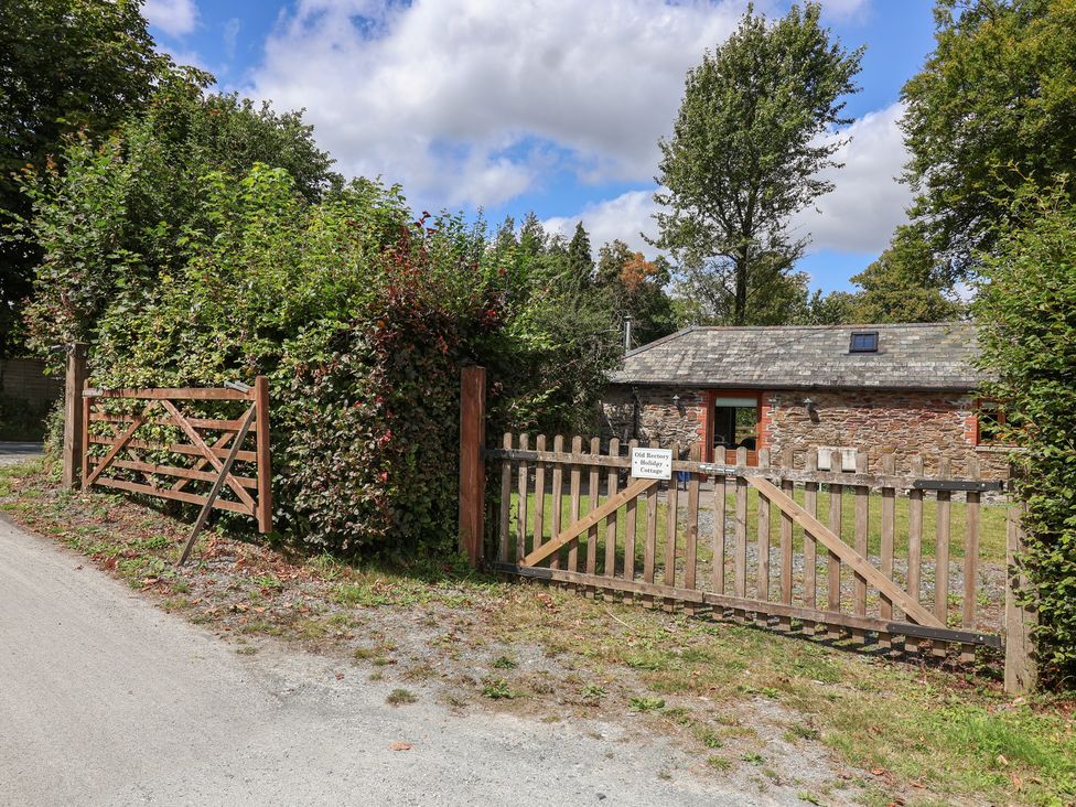A cottage with a wooden gate and fence at The Coach House in Tavistock
