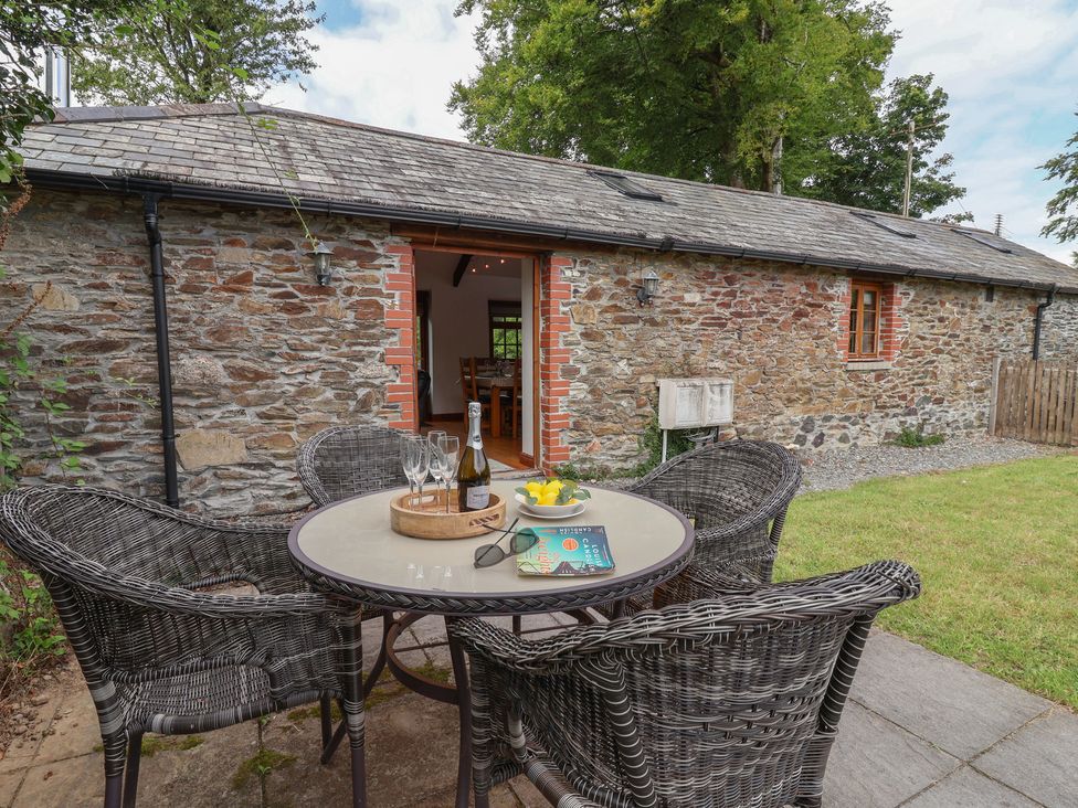 An outdoor seating area with a table and chairs at The Coach House in Tavistock