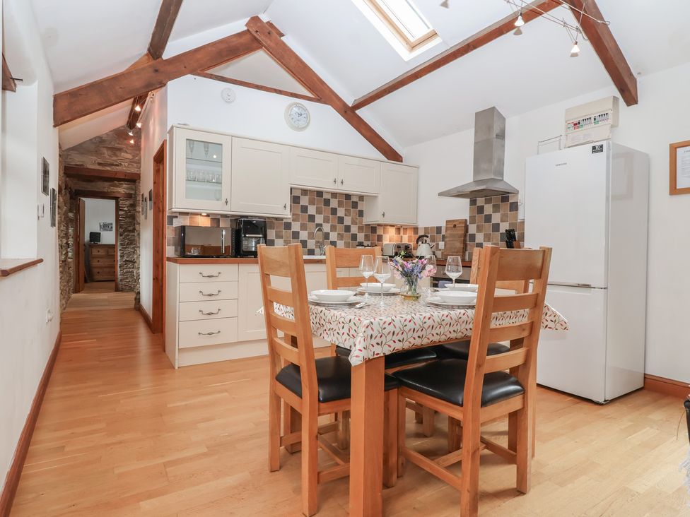 A kitchen with dining table and chairs at The Coach House in Tavistock