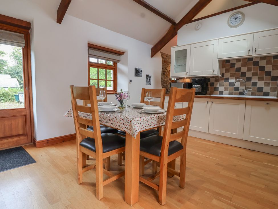 A dining room with a table and chairs at The Coach House in Tavistock