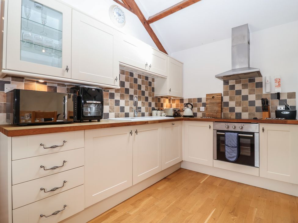 A kitchen with appliances and cabinetry at The Coach House Tavistock