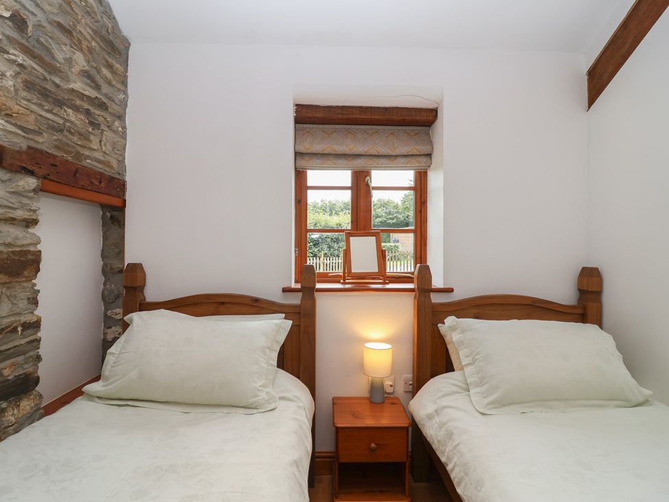 A bedroom with two beds and a window at The Coach House in Tavistock